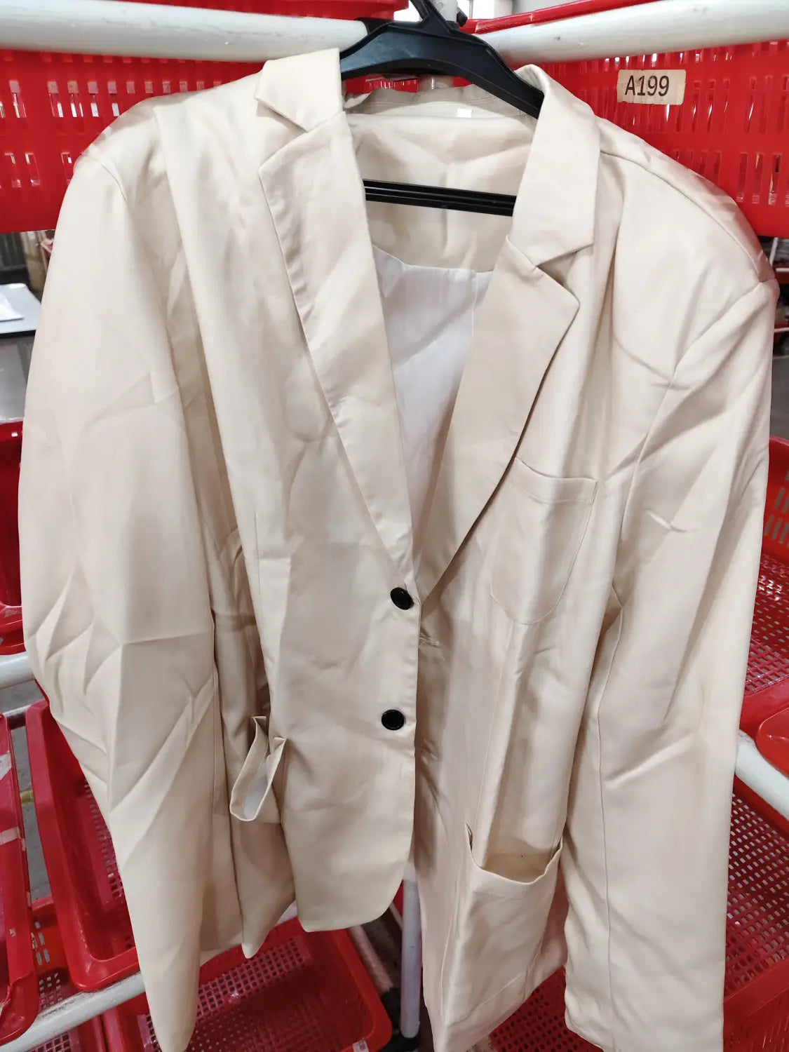 Men beige linen two piece suit blazer with black buttons and structured fit hanging on a black hanger.