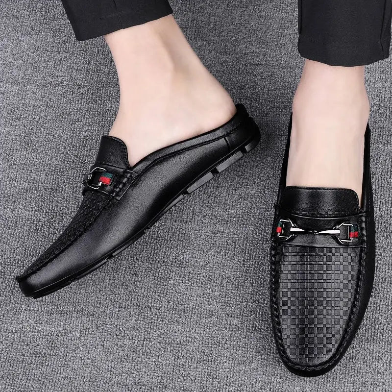 Men’s black leather mule loafers with woven texture and silver-toned buckle accents.