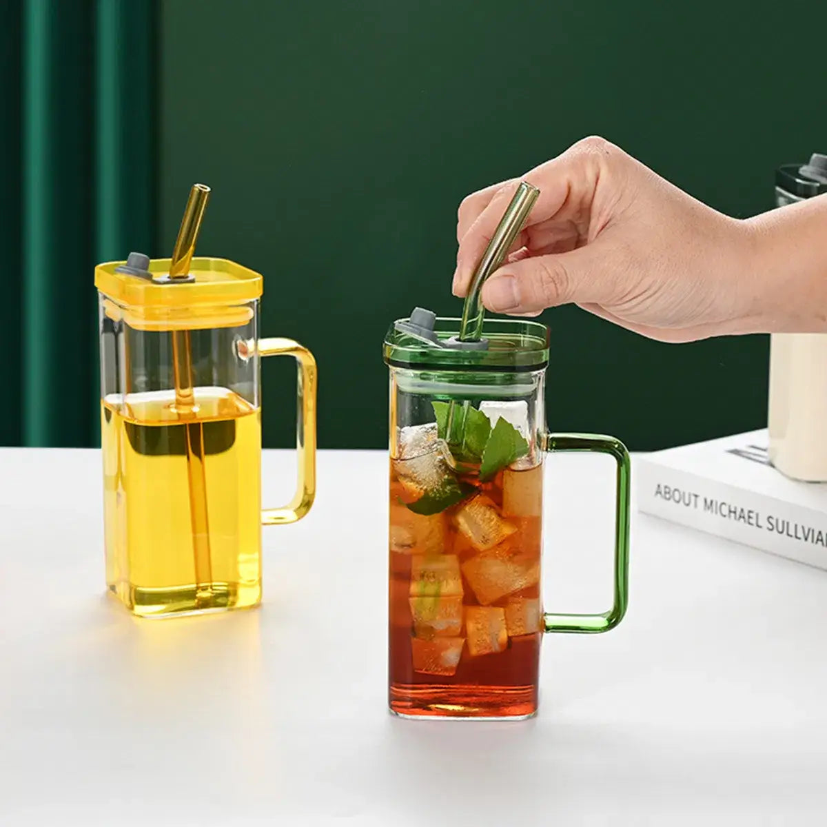 Tasse carrée en verre avec couvercle et paille de 12 oz, présentant des gobelets en verre transparent avec des couvercles verts et jaunes, des poignées assorties aux couleurs correspondantes, et des pailles métalliques.