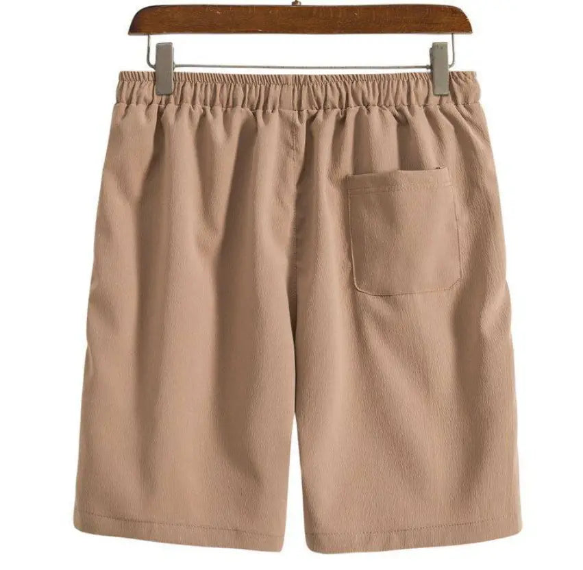 Short de plage en coton lin pour hommes beige présenté de dos, avec une ceinture élastique et une poche arrière unique.