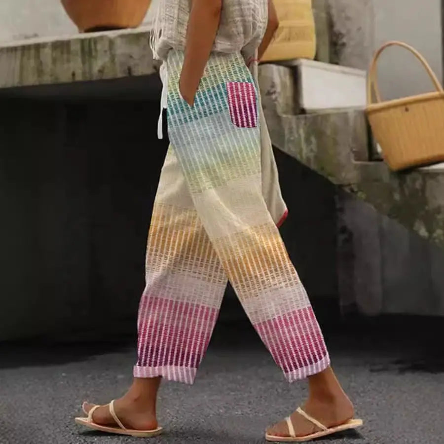 Casual patterned drawstring pocket pants featuring rainbow-striped woven trousers with a vibrant gradient from blue to pink and a textured fabric with a matching striped patch pocket.