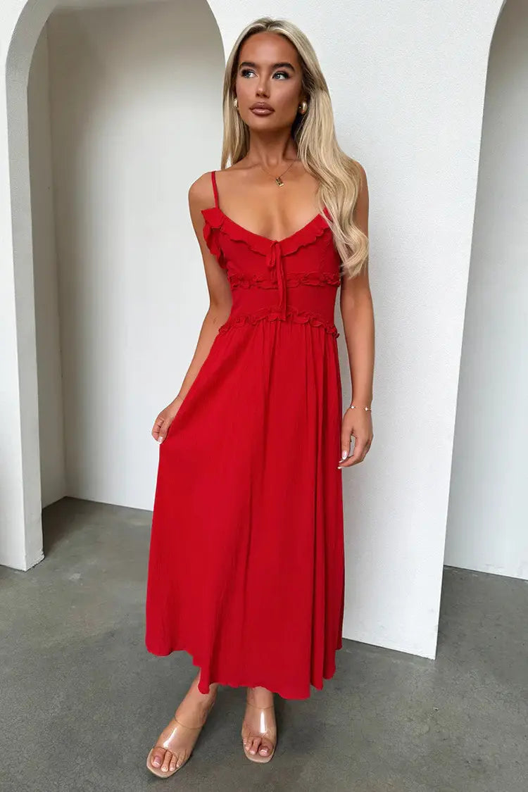 A vibrant red flowing maxi vacation dress featuring delicate ruffled straps and a fitted waistline.
