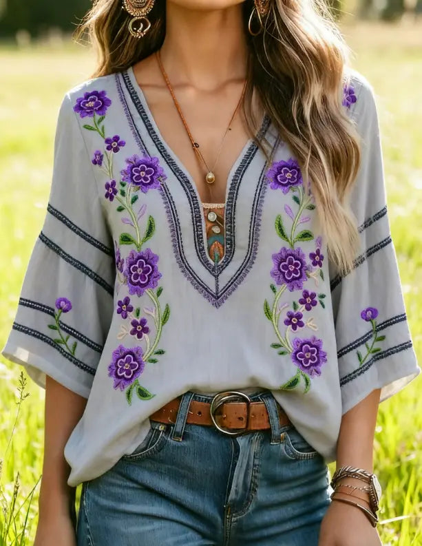 Hellgraue böhmische floral bestickte Bluse mit leuchtenden violetten Floralmustern und dunkelblauer Borte.