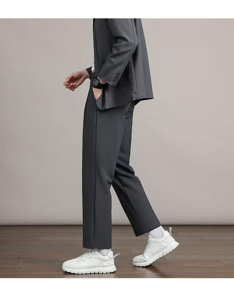 ダークグレーのテーラードなメンズミニマリスト・ストレートカットのドレスパンツ。すっきりとしたストレートレッグの仕立てと、控えめなサイドシームのディテールを備えています。