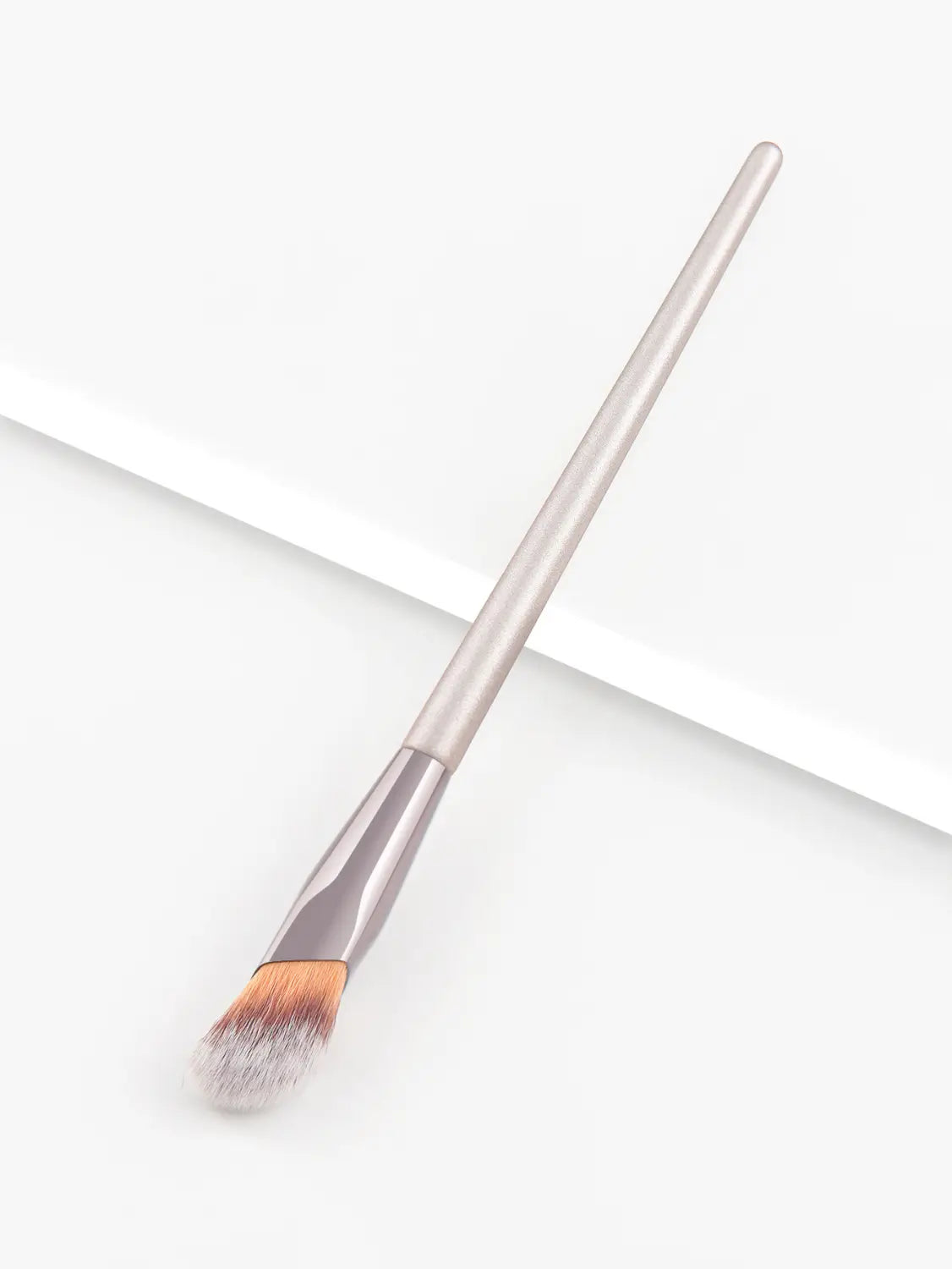 A sleek metallic silver finger belly makeup brush with a tapered handle and soft gradient bristles transitioning from light to dark brown designed as a professional contour tool.