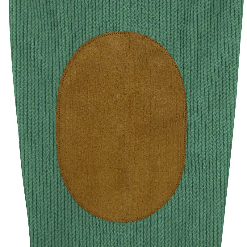 a tan suede elbow patch sewn onto green corduroy fabric of a slim fit corduroy patchwork pullover with contrast accents