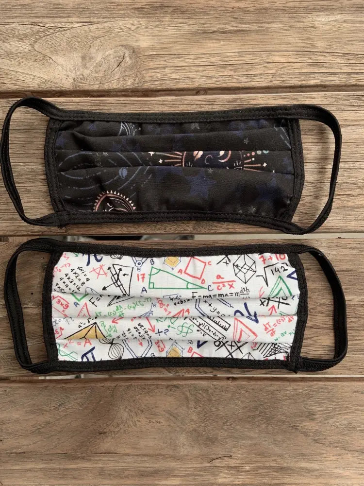 Two reversible cotton pleated face masks with celestial and math geometric designs in black and white colors