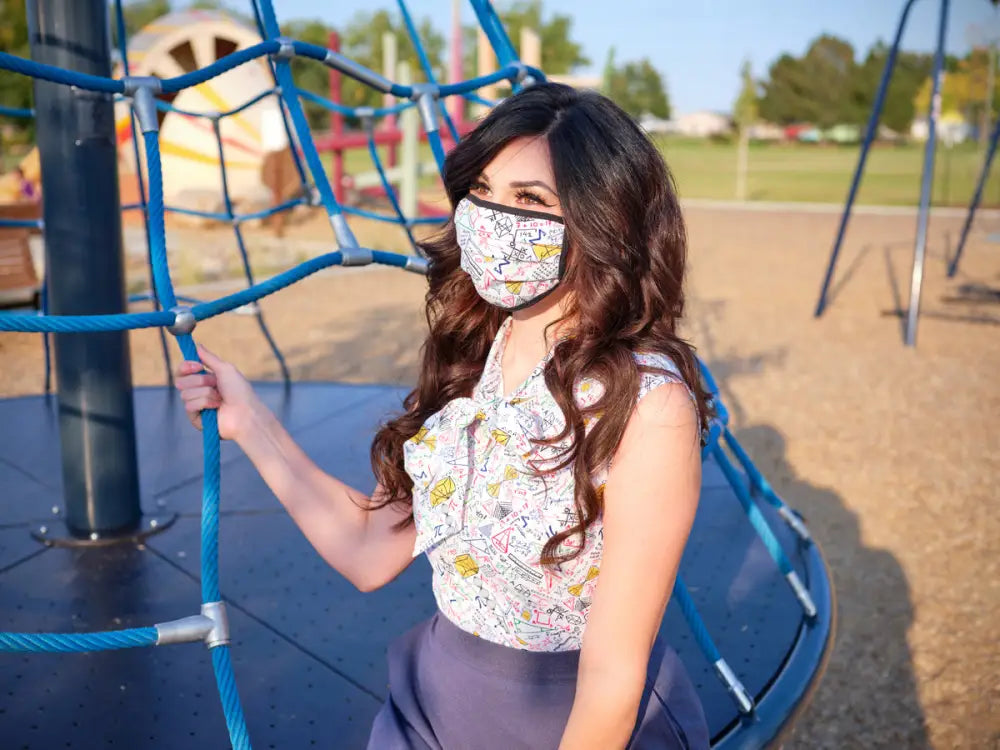 Celestial and math reversible cotton pleated face mask with a white base and colorful cartoonish doodle pattern