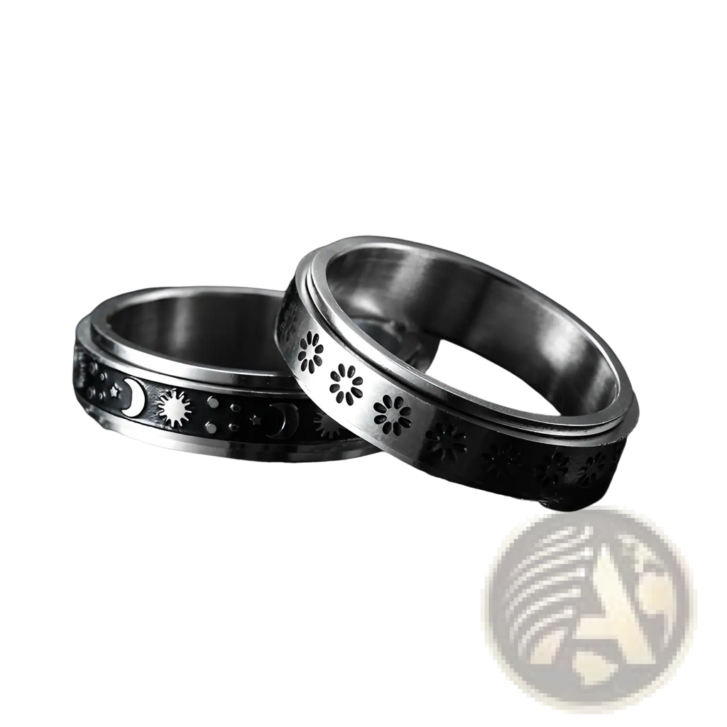 Two silver-toned stainless steel spinner rings with celestial moons stars and floral cutouts for anxiety relief