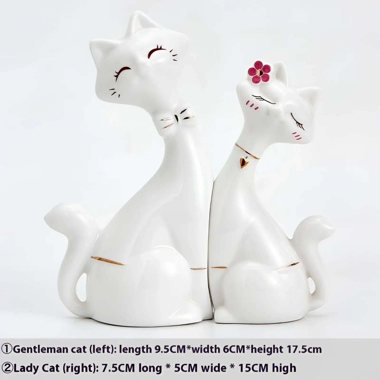 White ceramic figurines of two cats with a pink flower and a gold bow tie modern home decor accessory