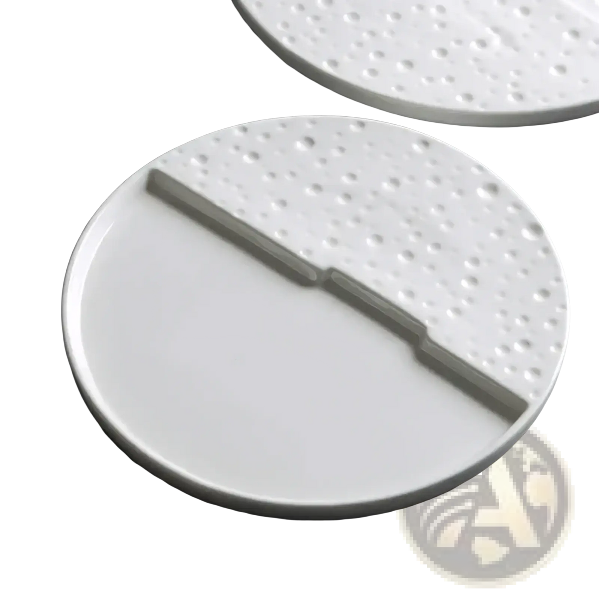 White ceramic decorative plate with textured dotted half and smooth half separated by a raised dividing ridge