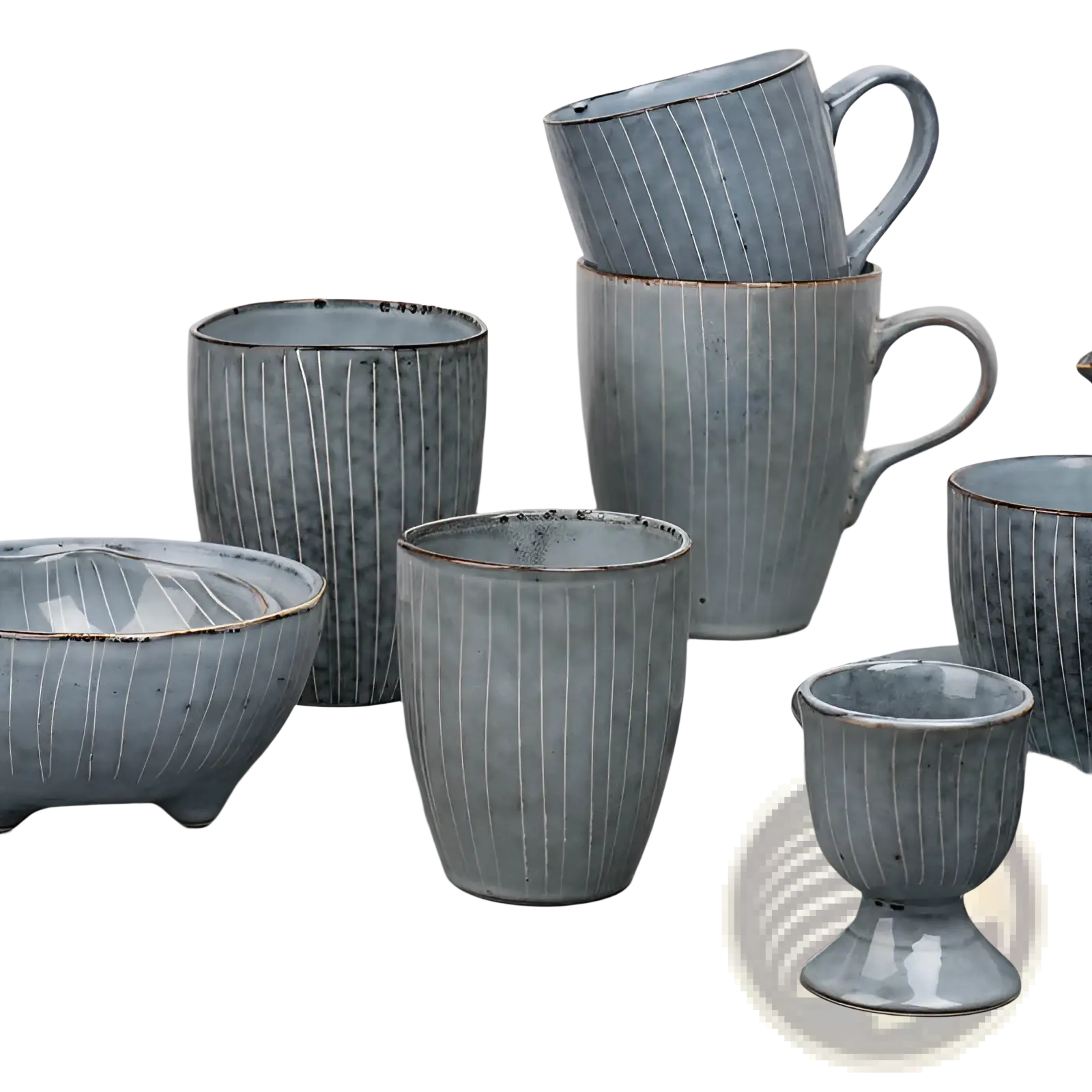A collection of handcrafted ceramic mugs and bowls in muted blue-gray glaze with ribbed texture and rustic brown rims