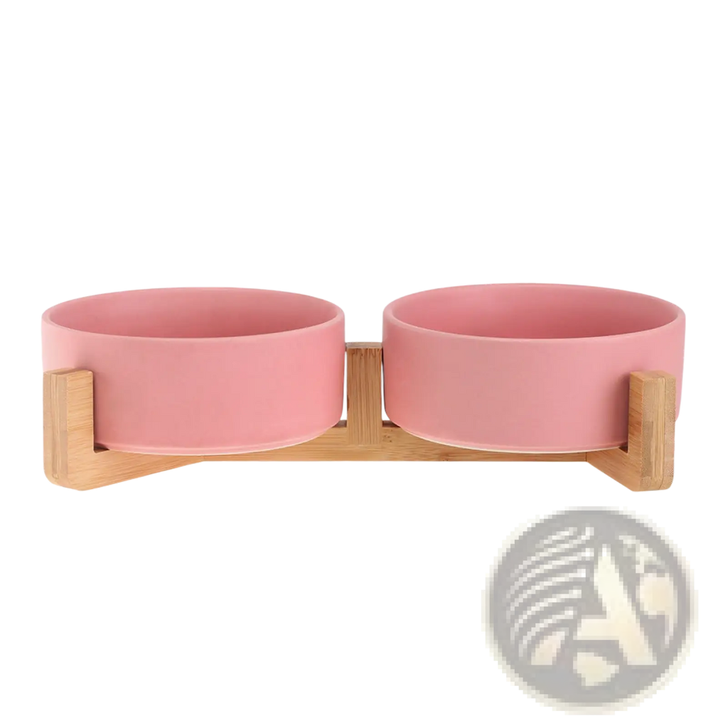 Pink ceramic double pet bowl mounted on a light wood stand for feeding cats or small dogs