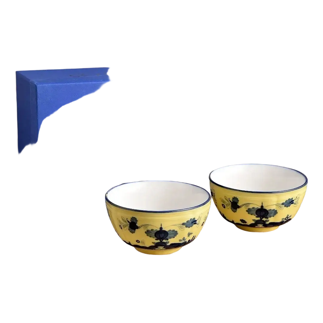 Yellow ceramic tea bowls with blue floral patterns white interior and matching rim from ceramic floral tableware set
