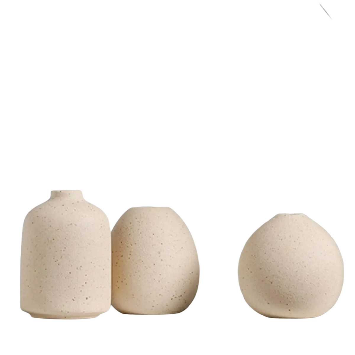 Three beige speckled ceramic flower vases of varying rounded shapes for boho tabletop decor on a white shelf
