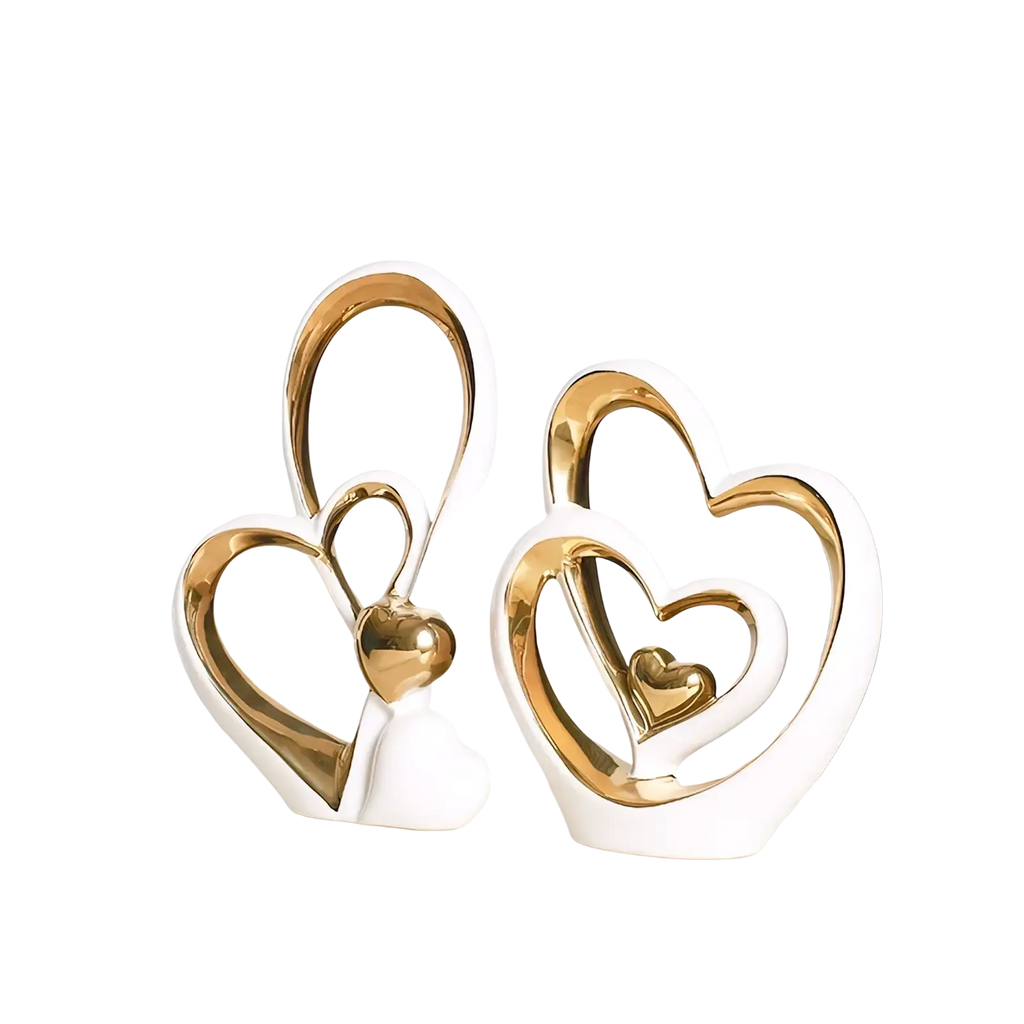 White ceramic heart sculptures with gold metallic accents featuring nested interlocking minimalist luxury decor design