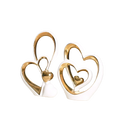 White ceramic heart sculptures with gold metallic accents featuring nested interlocking minimalist luxury decor design