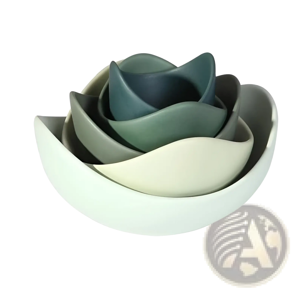 Set of five nested ceramic lotus bowls with matte finishes in white, gray, sage green, and navy blue arranged floral