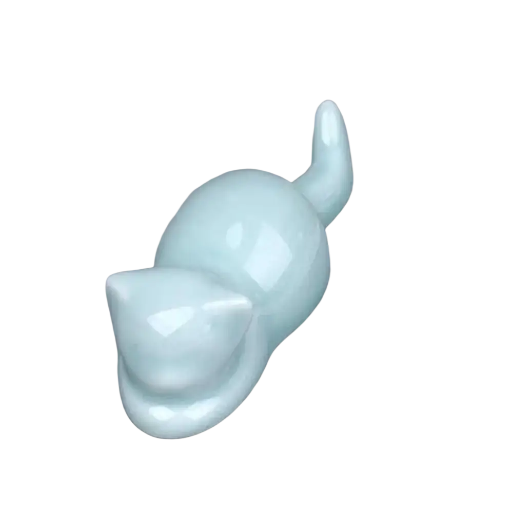 A smooth light blue ceramic pen holder and minimalist calligraphy brush rest shaped like a sleeping cat with glossy finish