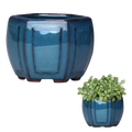 Deep blue glazed ceramic plant pot with vertical ribbed texture rounded feet and drainage hole for indoor plants