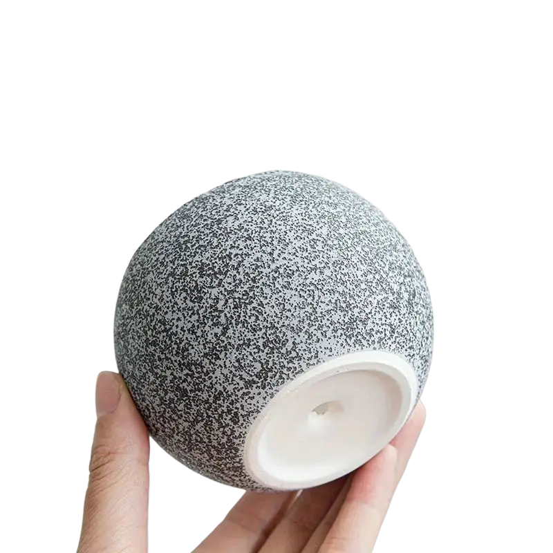 Gray speckled ceramic planter with a smooth white circular base and wooden saucer for succulents