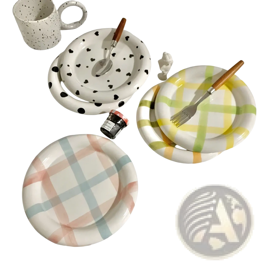 Set of three ceramic plates with playful black heart, yellow green plaid, and pastel checkered patterns with wooden utensils