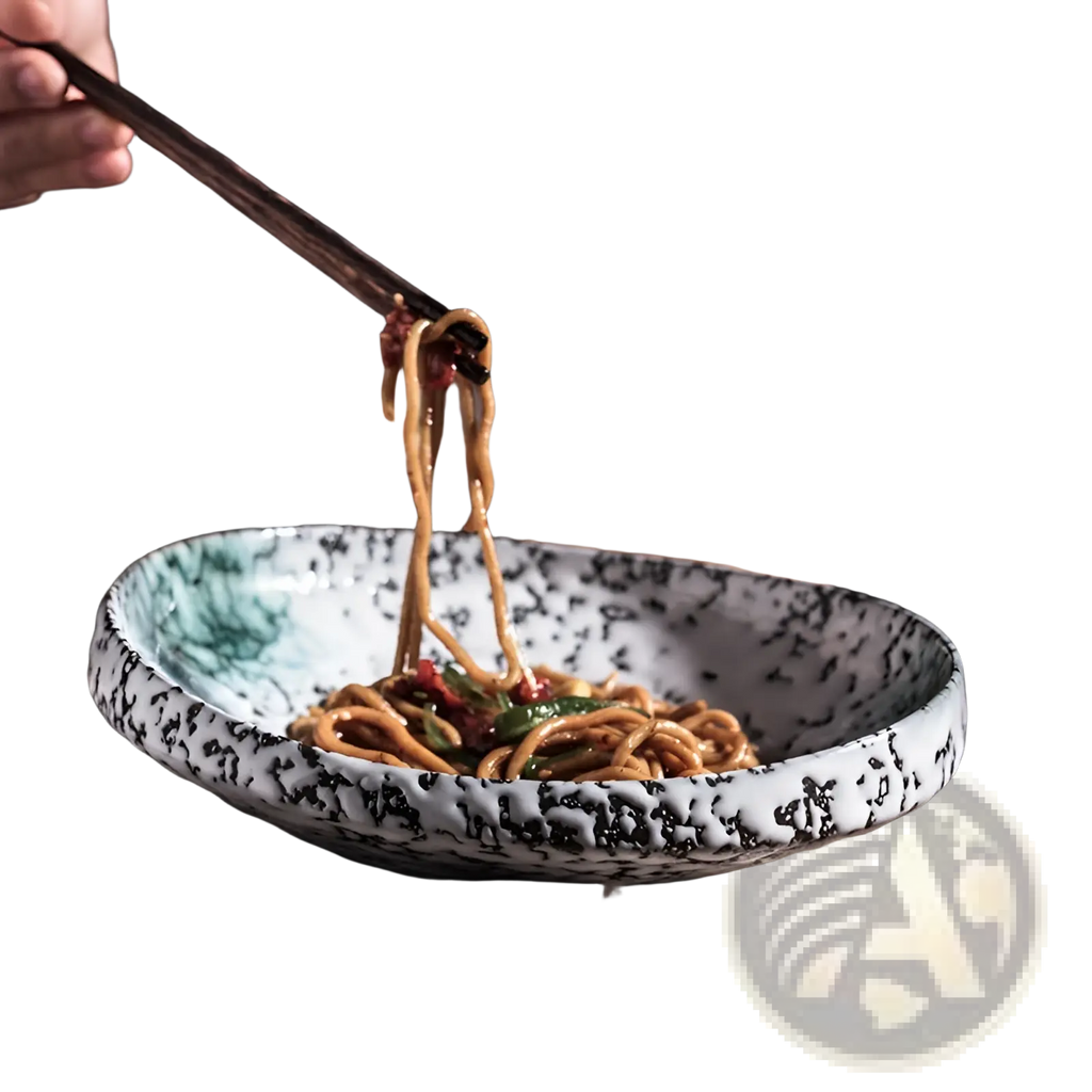 A white ceramic speckled serving bowl with black glaze and green brushstrokes holding stir-fried noodles for home kitchens
