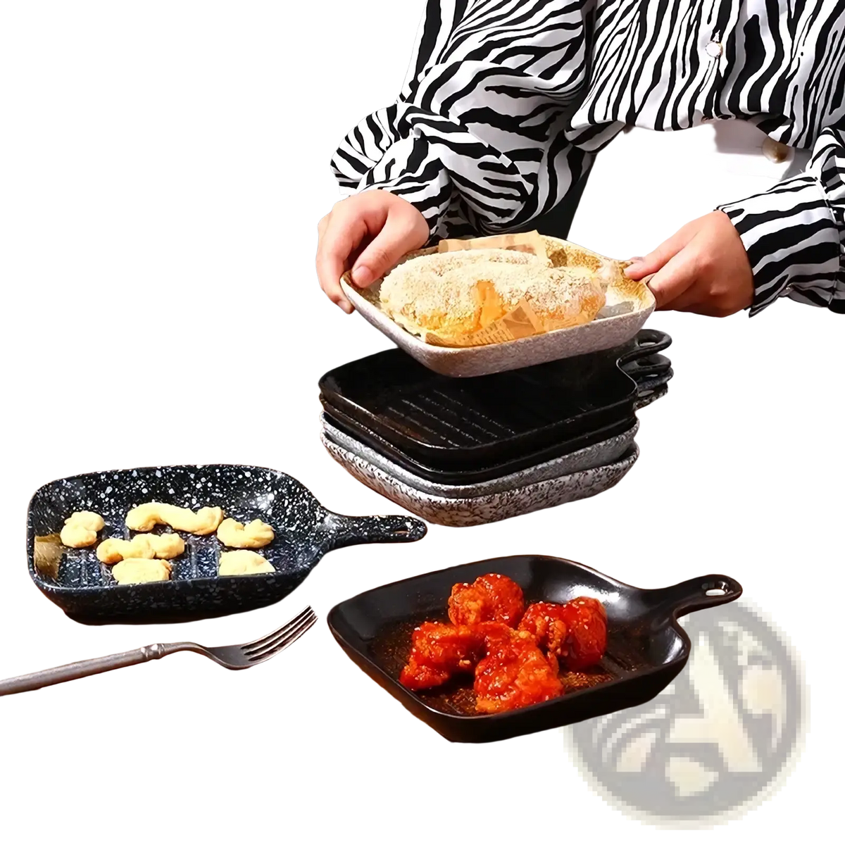 A speckled gray cast iron skillet with handle held by person in zebra print shirt alongside ceramic square baking plate with handle