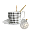 Black and white plaid ceramic teacup with matching saucer from ceramic tea set with plaid teapot and gold trim tray