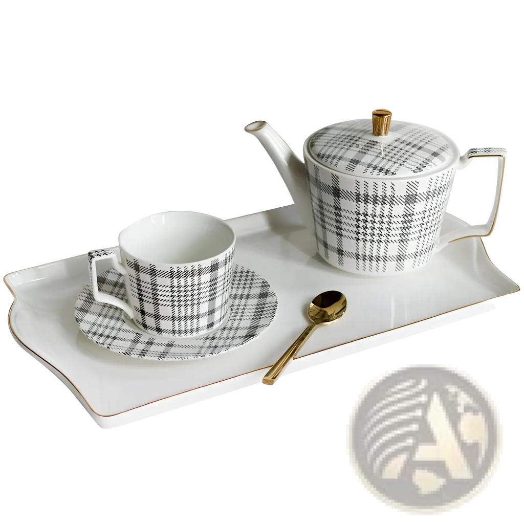 White ceramic teapot with black and gray plaid pattern and gold-trimmed lid knob and handle in ceramic tea set