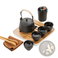 Black cast iron teapot with textured surface and rope wrapped handle from ceramic travel tea set with bamboo tray and case