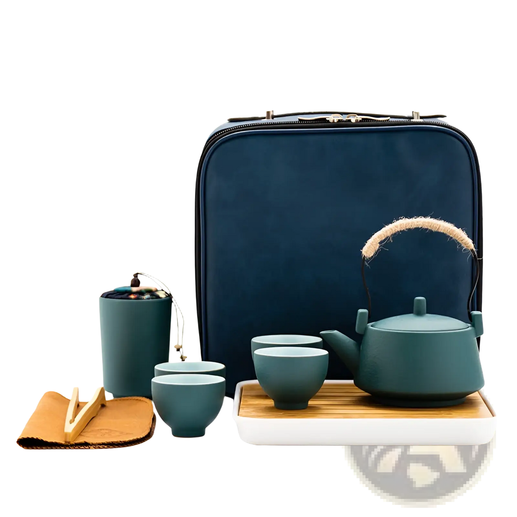 Teal ceramic travel tea set with woven handle and matching cups on bamboo tray beside navy blue carrying case