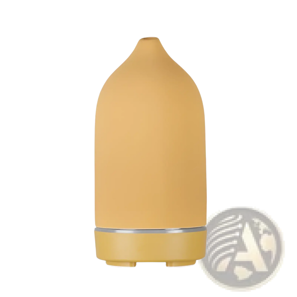 A sleek matte mustard-yellow ceramic ultrasonic aroma diffuser and humidifier with minimalist design and silver accent band