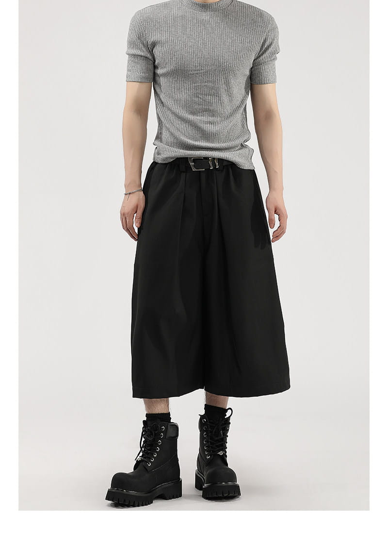 Short de costume pour hommes à jambes larges plissées noir, présentant une coupe moderne épurée et une texture subtile