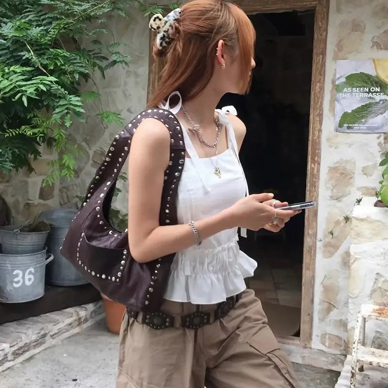 Brown studded leather shoulder bag with retro hobo purse design featuring rich brown color and durable leather material.