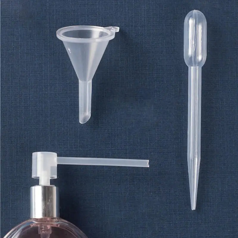 essential oil dispenser tool set 3pcs mini funnels featuring clear plastic funnel and dropper set beside a soap dispenser with silver pump.