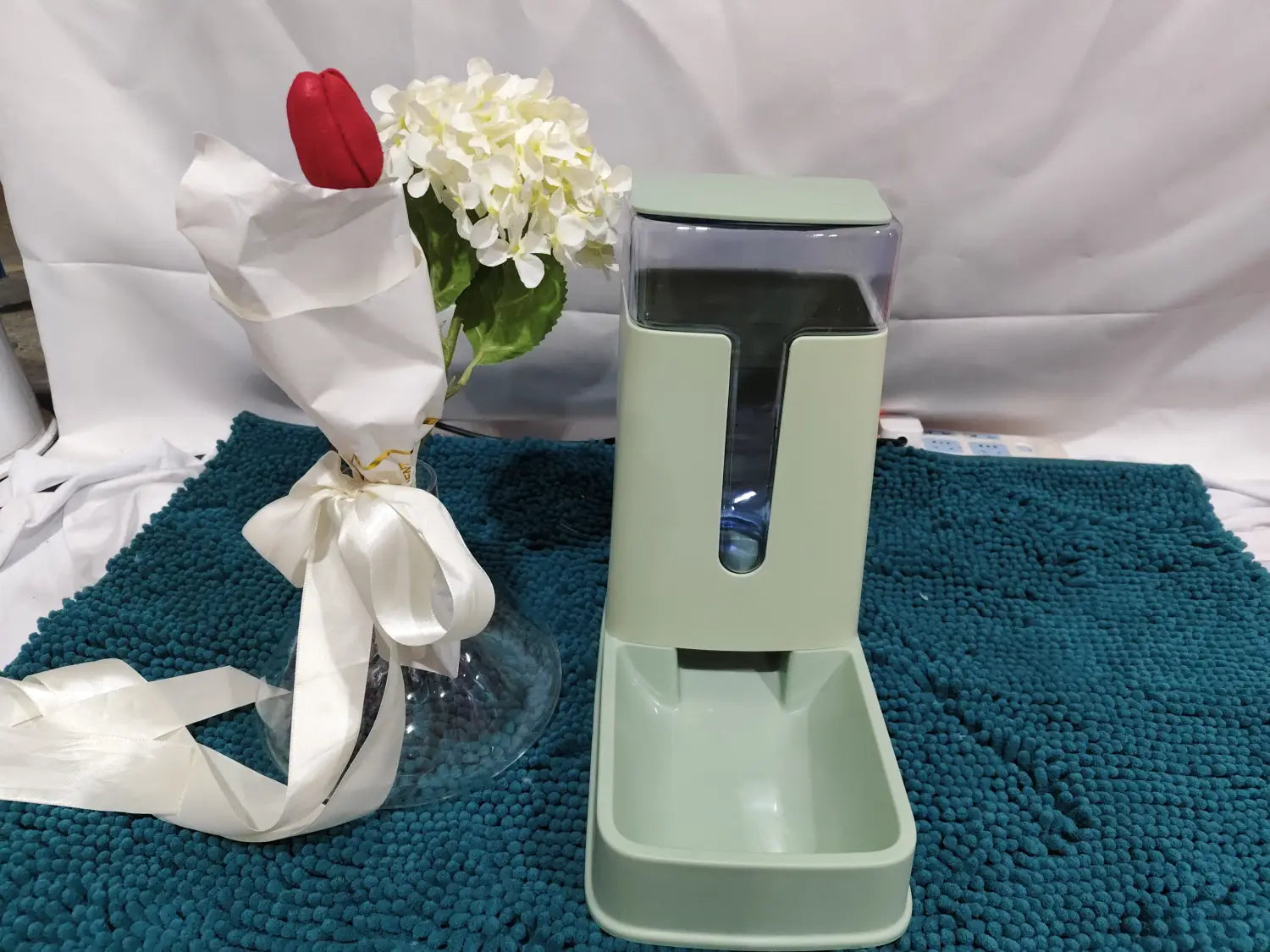 Mint green automatic pet feeder with transparent food compartment and matching tray designed for convenient feeding and water dispensing.
