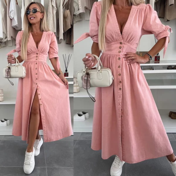 A soft pink button front midi dress with puffed sleeves and a high slit made of denim material.