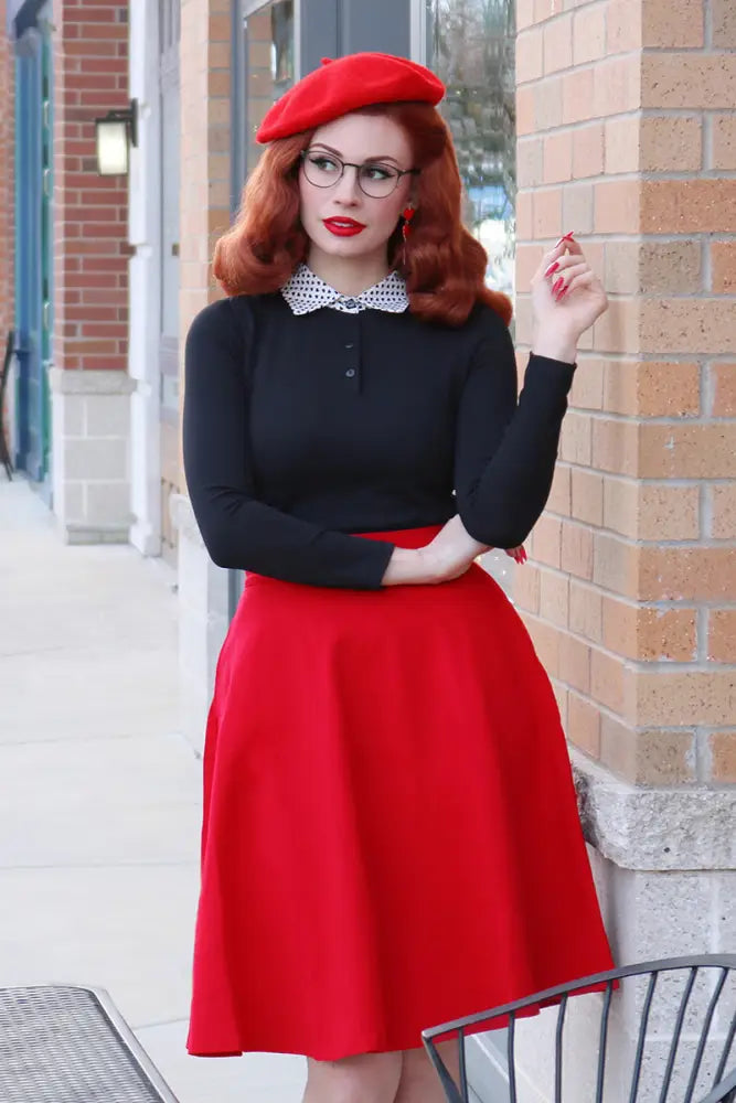 A vibrant red beret with a smooth structured crown and softly curved brim complementing the charlotte red vintage skirt