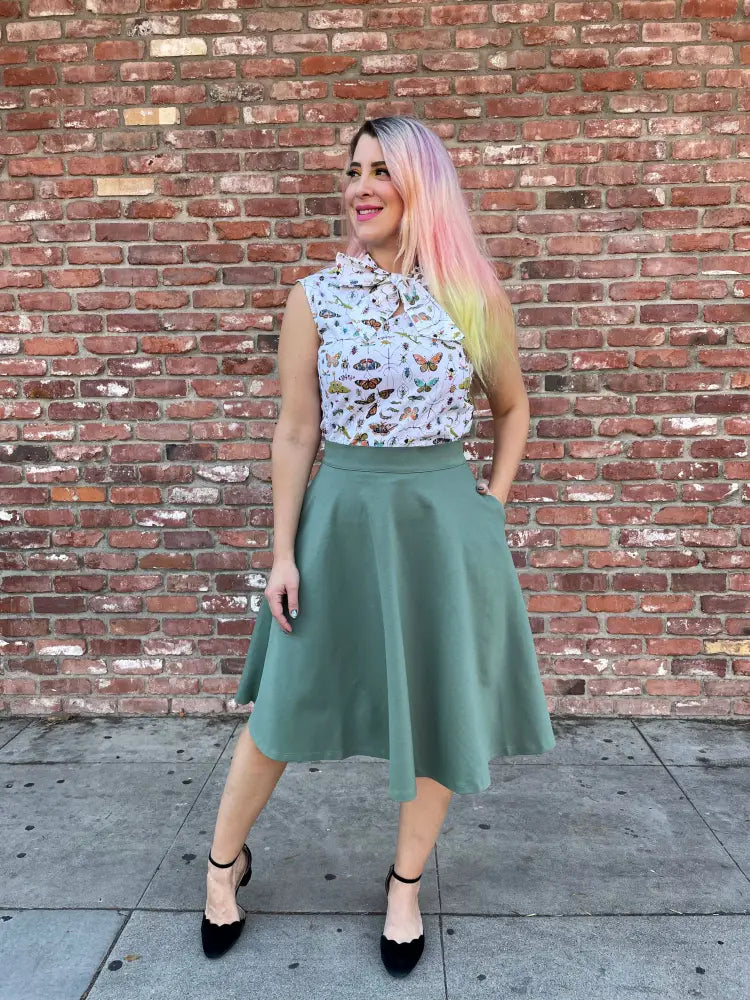 A sleeveless white blouse with butterfly print and tie-neck paired with charlotte sage plus size vintage a line circle skirt