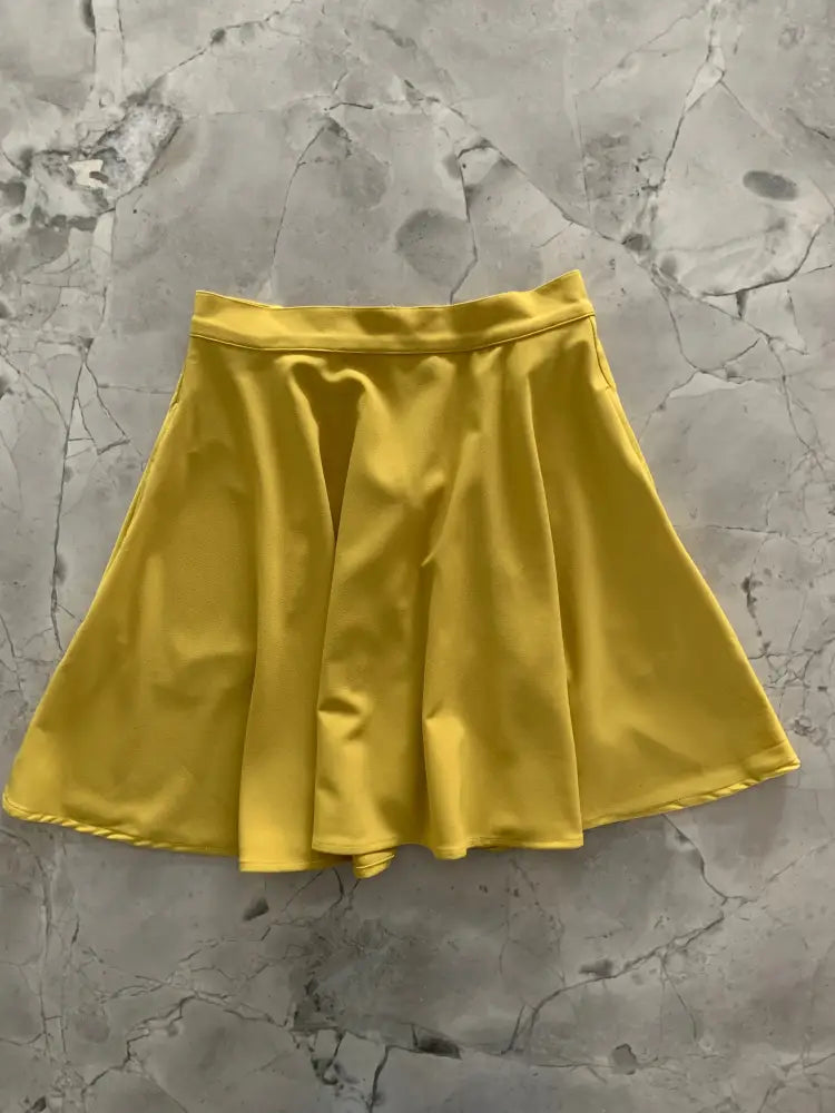 Chartreuse satin pleated mini skirt with pockets featuring a vibrant yellow smooth glossy finish and neatly stitched hem