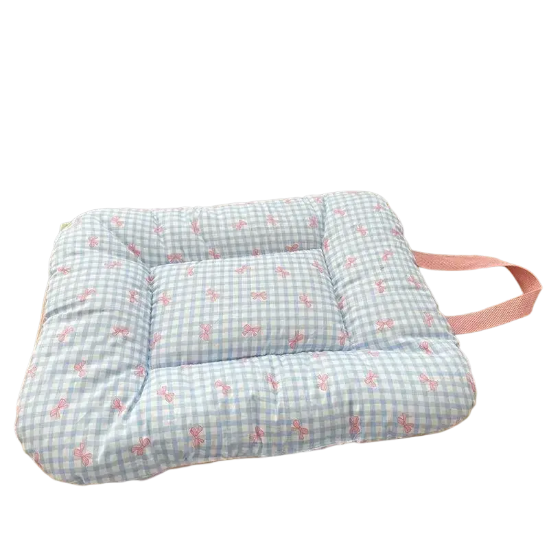 A soft quilted blue and white checkered cotton pet bed mattress with pink bow tie motifs and matching pink strap