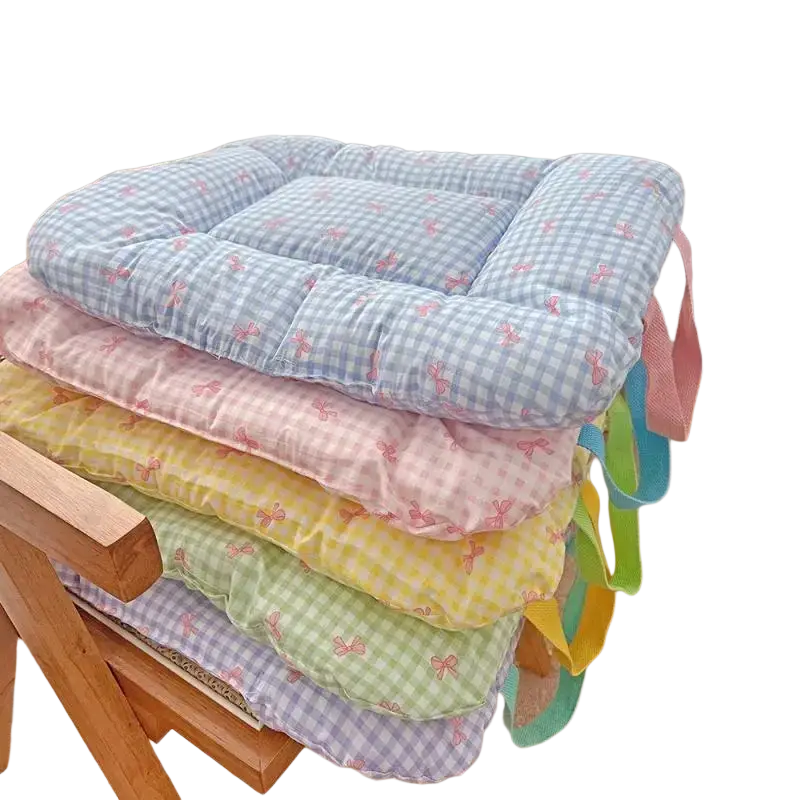 Stacked pastel checkered cotton pet bed cushions with pink bow patterns and colorful fabric ties for comfort