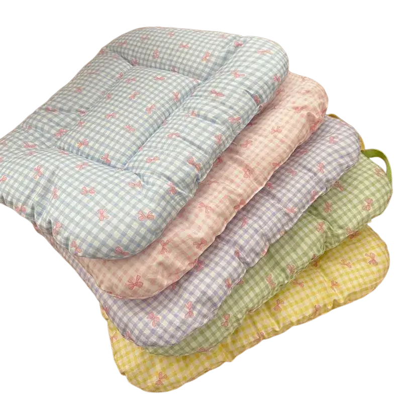 Stacked pastel-colored checkered cotton pet bed mattress pads with pink bow patterns for comfortable use