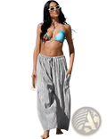 A woman wears loose wide-leg checkered harem pants with vertical black and white stripes and a drawstring waistband