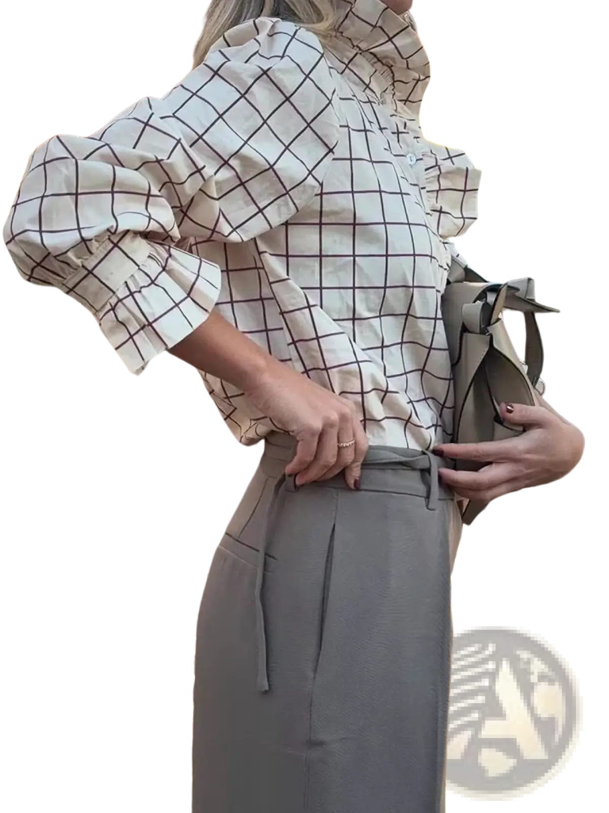 A woman wears a white chiffon checkered blouse with ruffled sleeves paired with high-waisted gray trousers