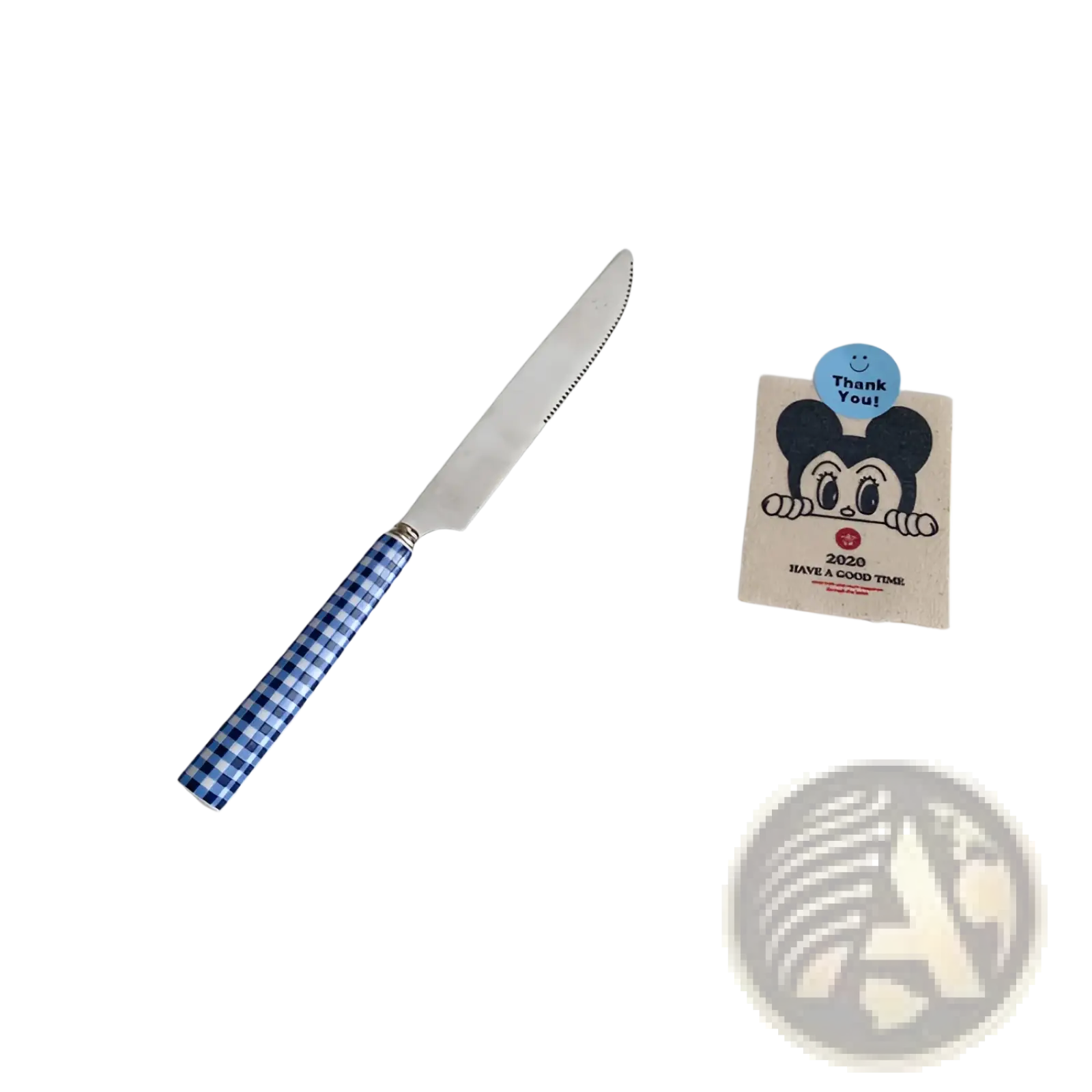 A blue and white checkered handle knife with a serrated stainless steel blade from a cutlery tableware set