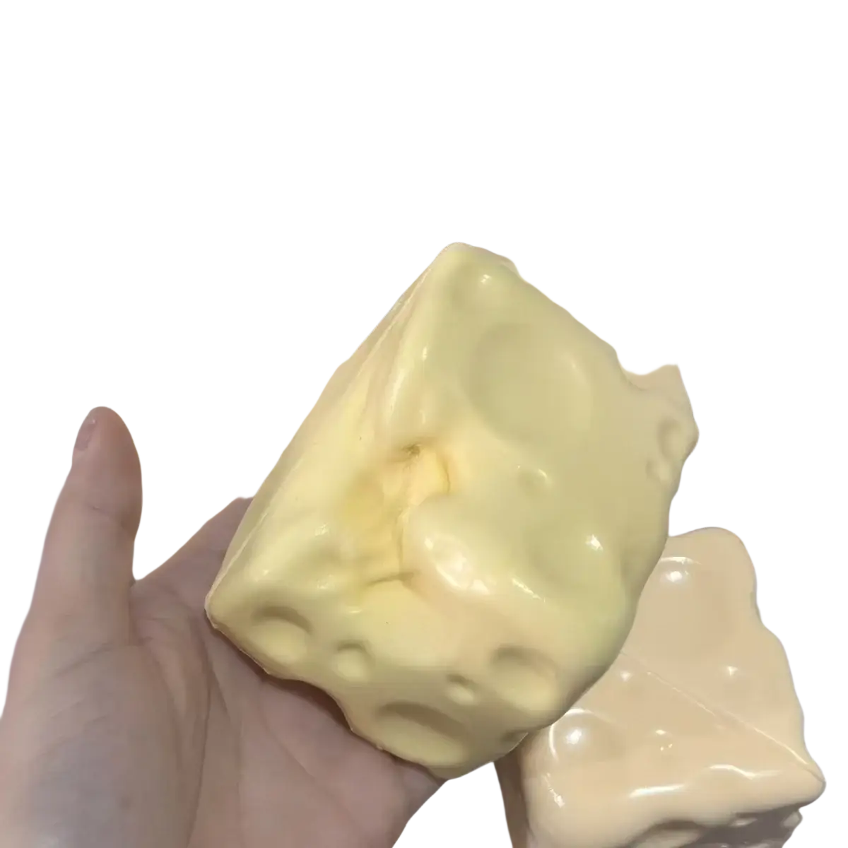 A pale yellow glossy cheese cube stress ball soap with textured holes designed as a cube stress ball sensory toy