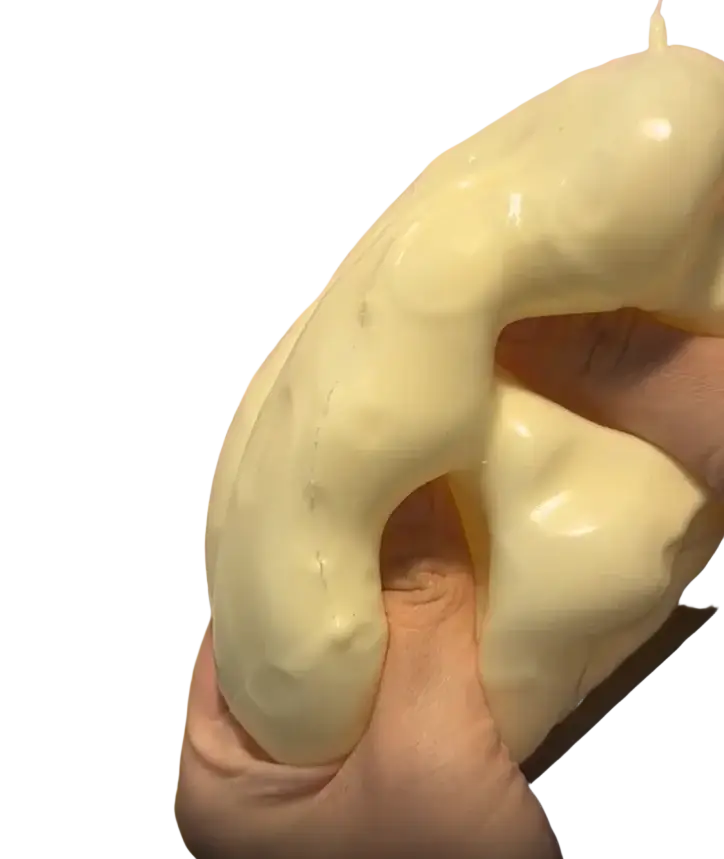 A creamy off-white glossy cheese fidget toy squishy held in hand for stress relief and toy stress relief use