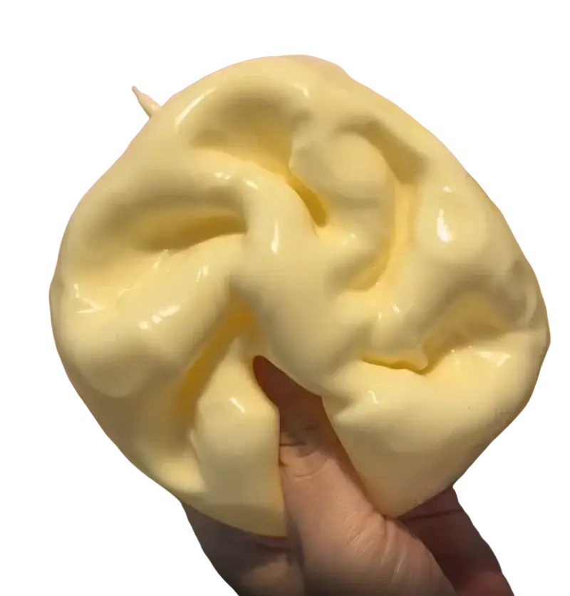 A pale yellow glossy cheese fidget toy stress relief squishy with soft squishy texture and irregular wavy contours